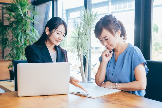 賃貸業者で契約の説明を受けている女性